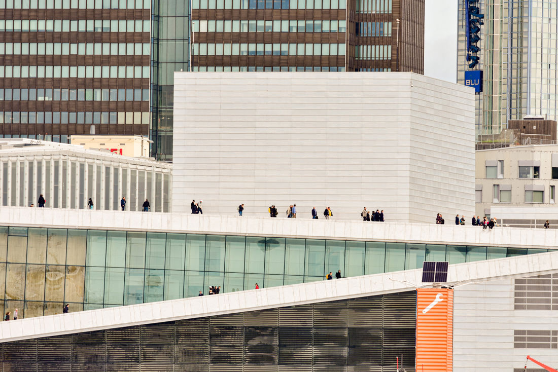 en gruppe mennesker som går på en gangvei mellom bygninger